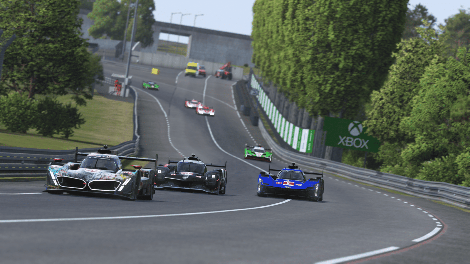 Le Mans pit lane at night with floodlights — endurance racing teams during the 24 Hours of Le Mans overnight stint