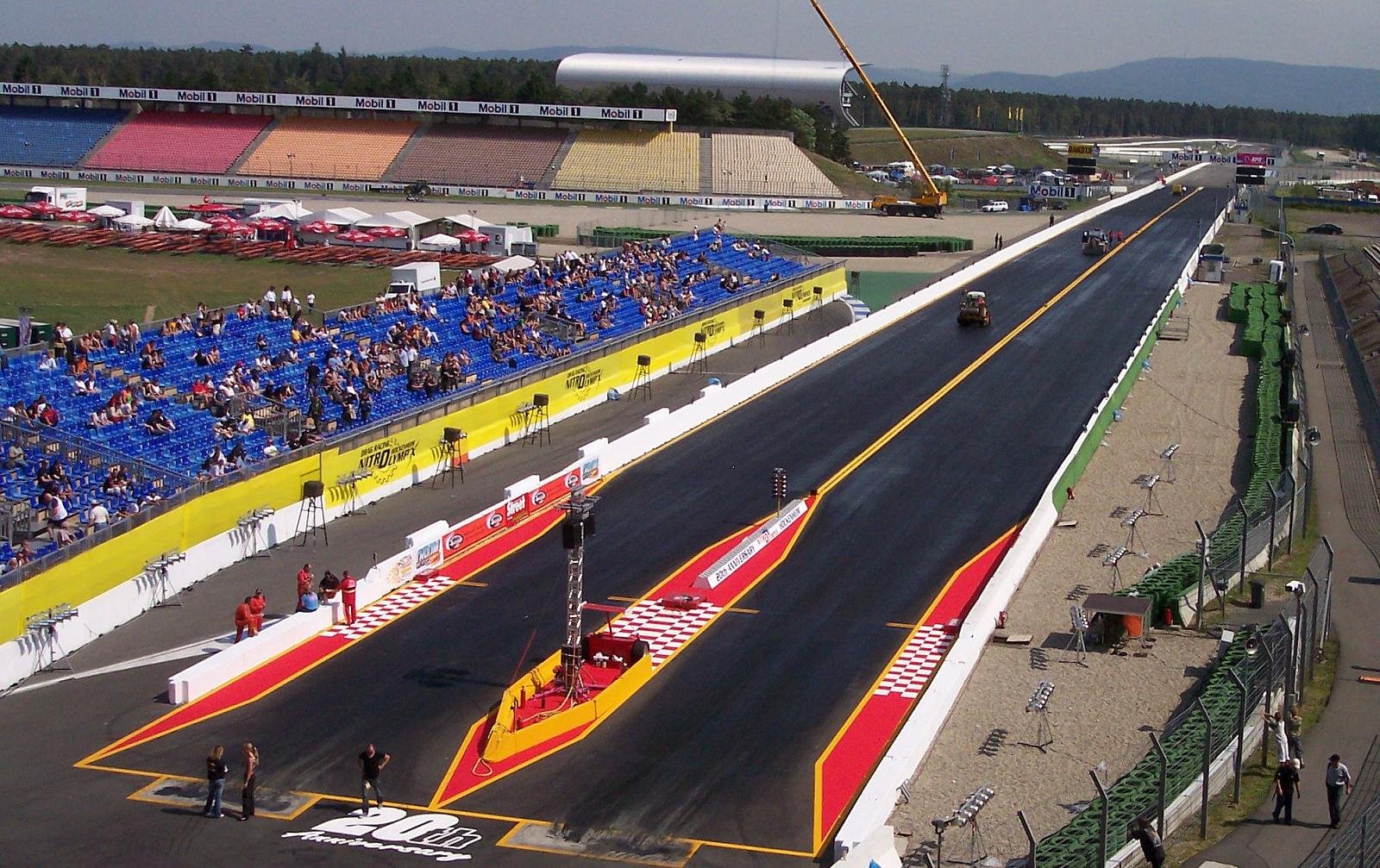 NHRA drag strip aerial view — 1000-foot racing surface prepared with traction compound for Top Fuel dragsters