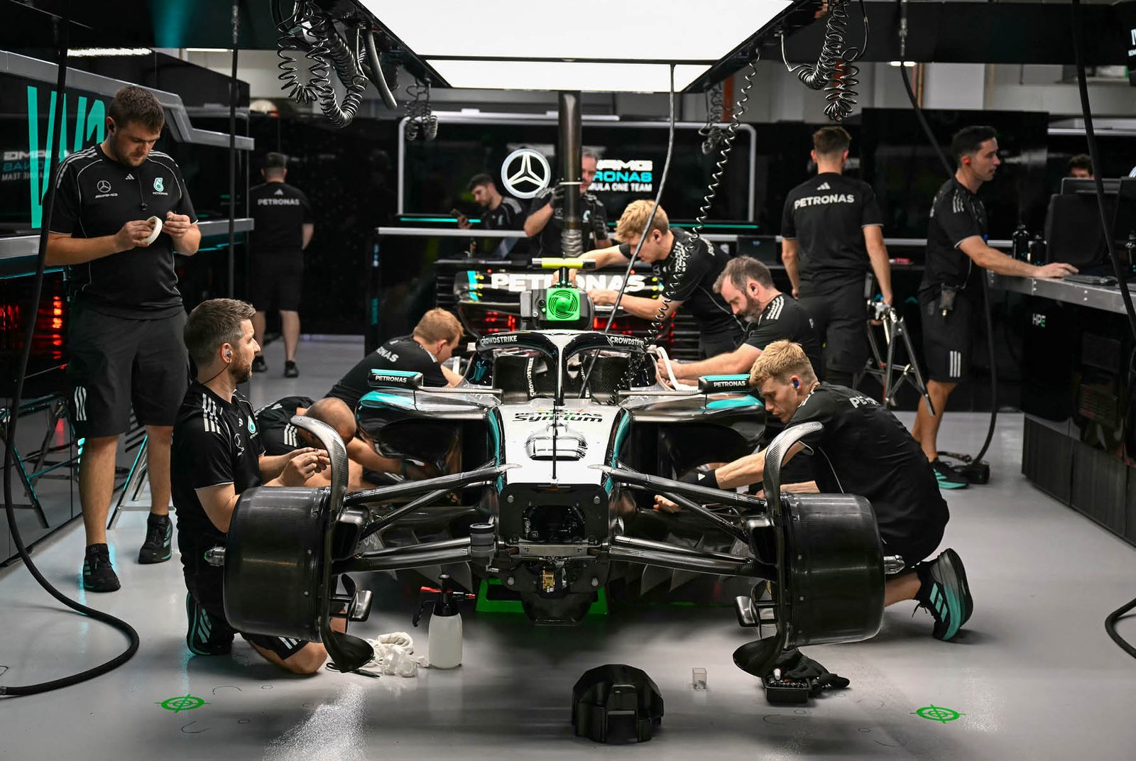 Formula 1 team garage pit lane β team engineers and mechanics working on F1 car during race weekend