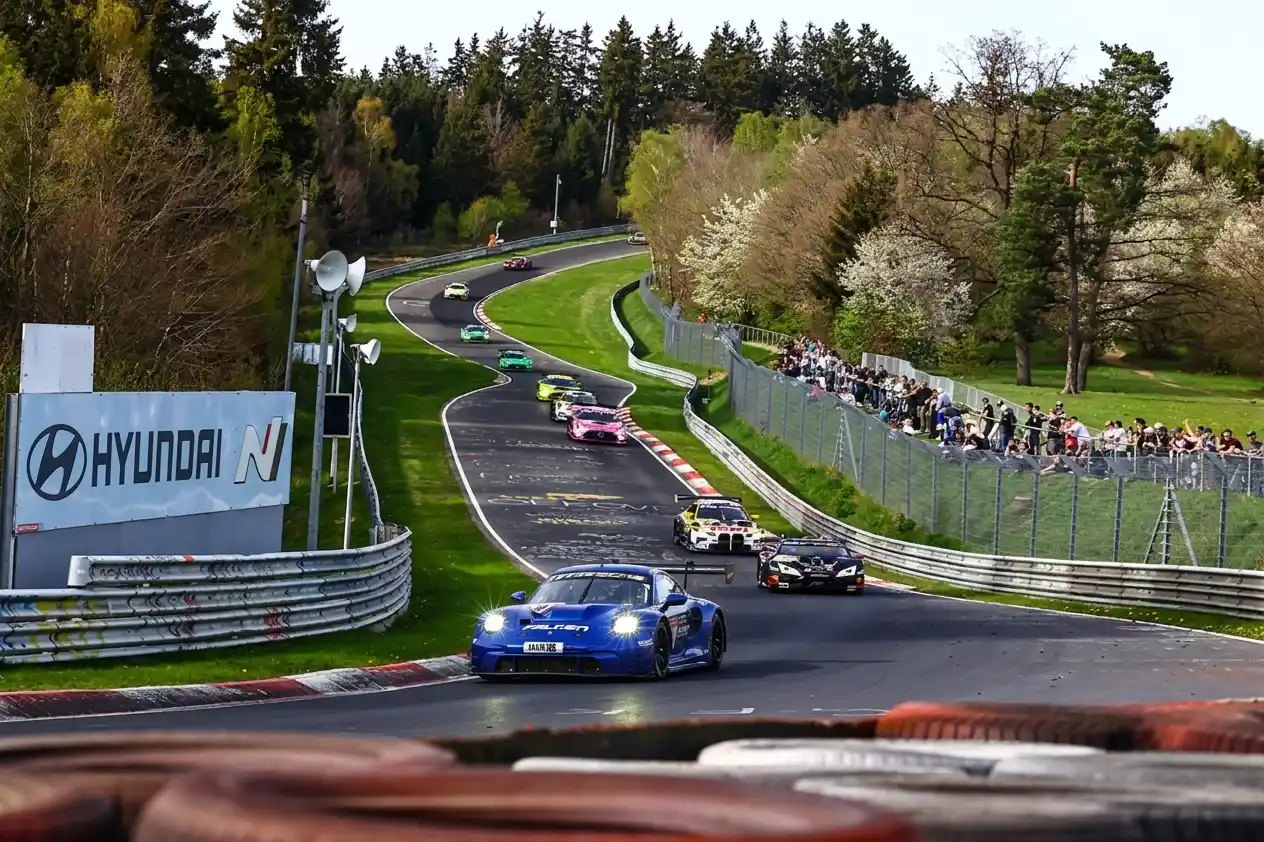 Endurance race cars navigating a fast corner on the Nürburgring Nordschleife during the 24 Hours race