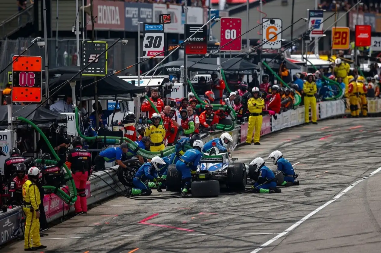 IndyCar pit lane crew working on car during race — 2026 NTT IndyCar Series pit stop technology and race strategy