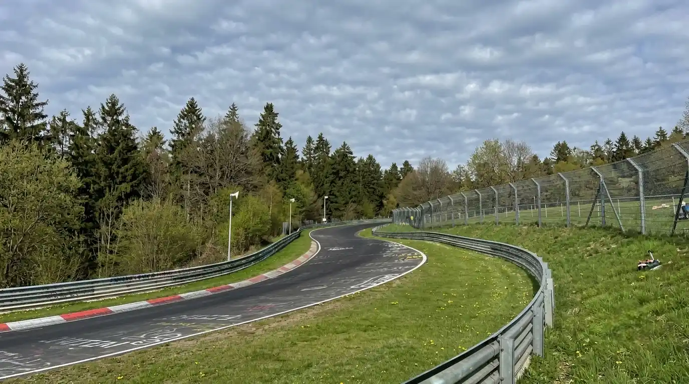 GT3 racing car at Nürburgring Nordschleife at night — headlights cutting through darkness on the Green Hell circuit
