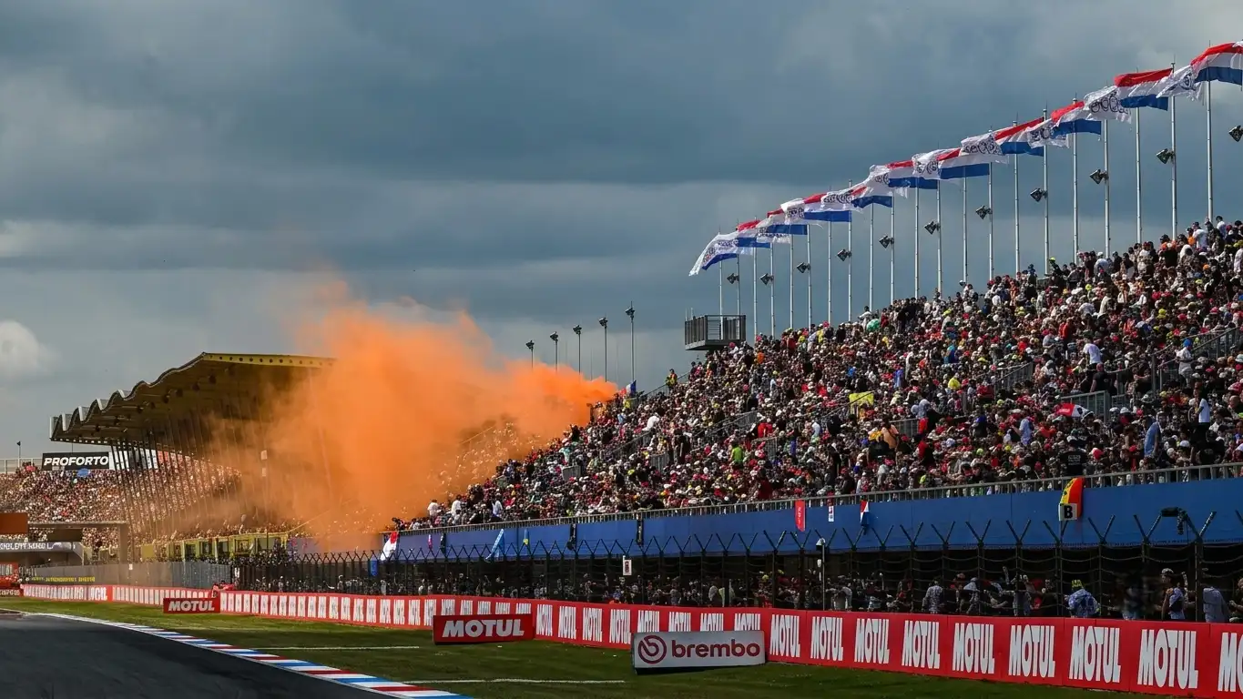 MotoGP riders on starting grid at sunset — Dutch TT 2026 race weekend atmosphere