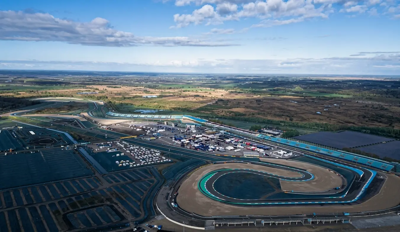 Motorcycle at full lean mid-corner on a racing circuit — TT Circuit Assen layout demands total commitment