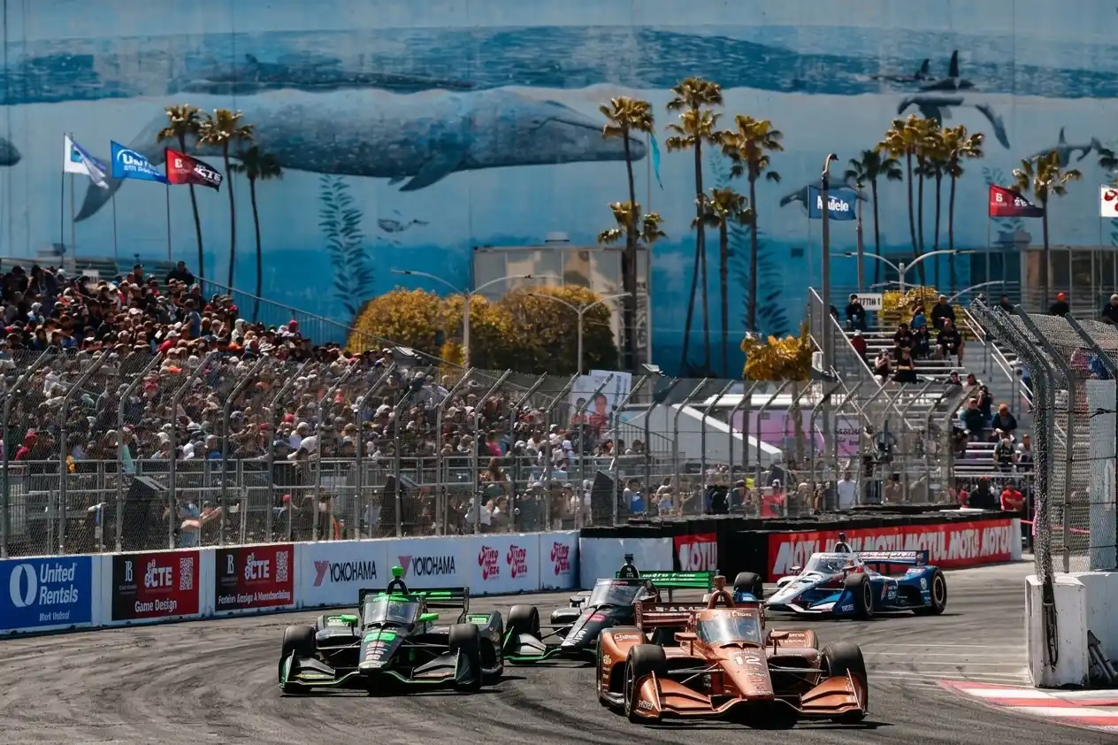 Racing driver in open-wheel car at speed on natural terrain road circuit — IndyCar Road America