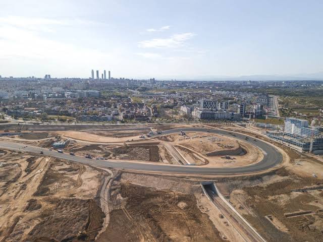 Banked race track corner under construction showing steep asphalt incline for high-speed cornering