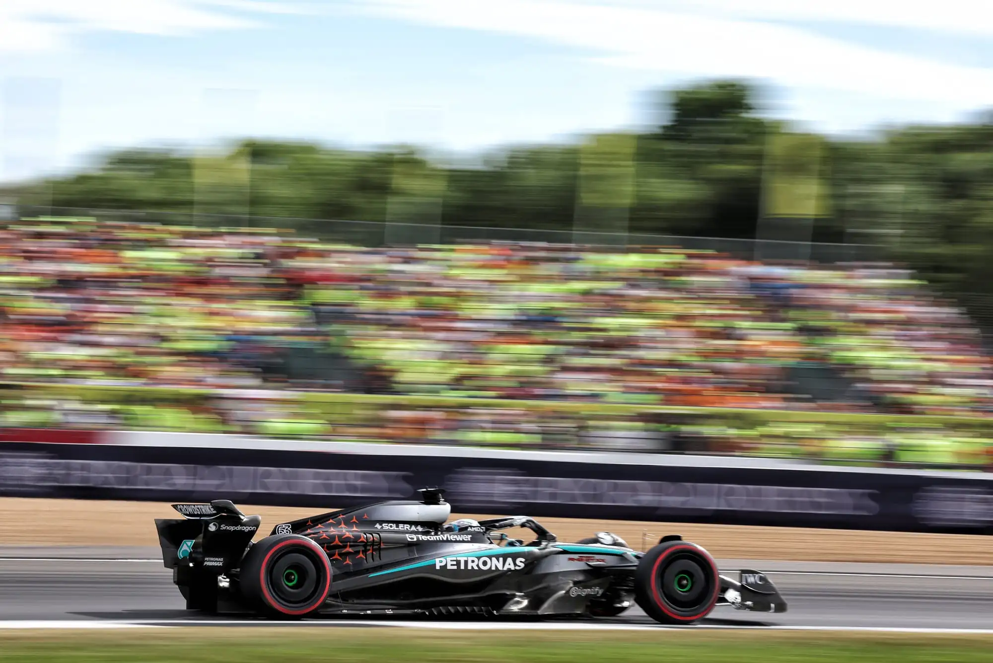 Formula 1 cars racing wheel to wheel through a high-speed corner at Silverstone circuit