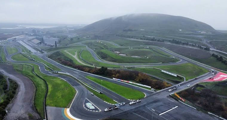 Race cars navigating a challenging road course corner — Sonoma Raceway wine country backdrop California