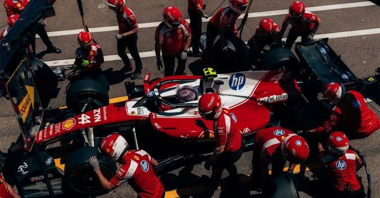 Formula 1 pit crew performing a tyre change during a Grand Prix pit stop