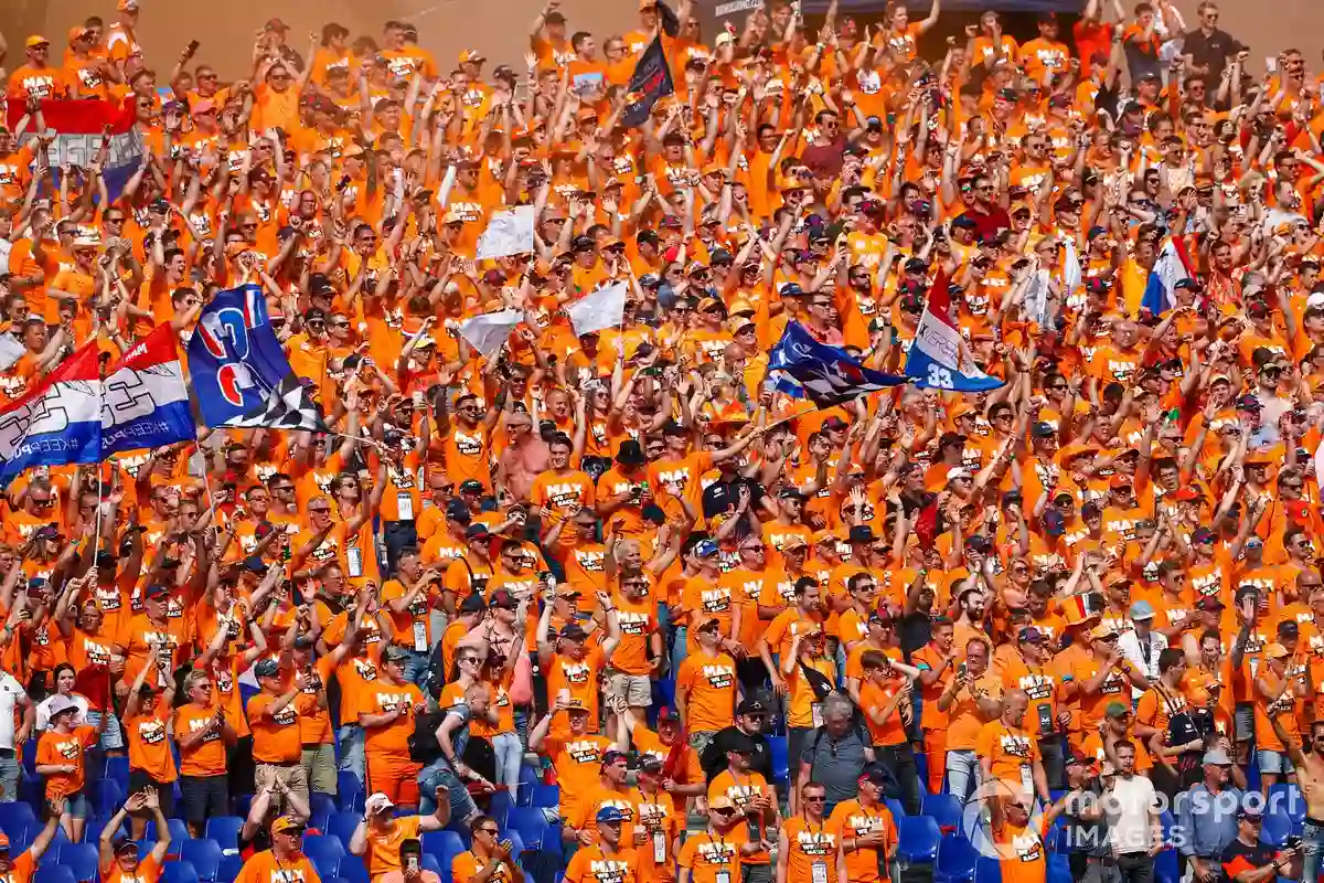 Aerial view of racing circuit grandstands packed with orange-clad fans representing Dutch Grand Prix atmosphere at Zandvoort