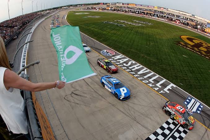 NASCAR Cup Series cars side by side at the start of a race — green flag moment captured from the grandstands