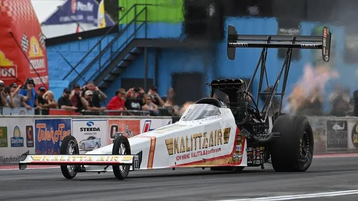 Drag racing car at full throttle with smoke and power — representing NHRA Top Fuel competition at Summit Motorsports Park Norwalk 2026