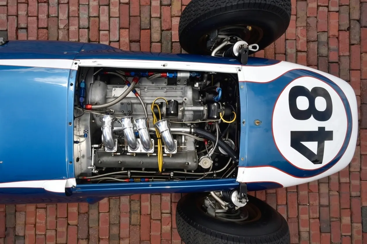 The Scarab Formula 1 car at rest, showing its front-engine layout and handcrafted aluminium bodywork