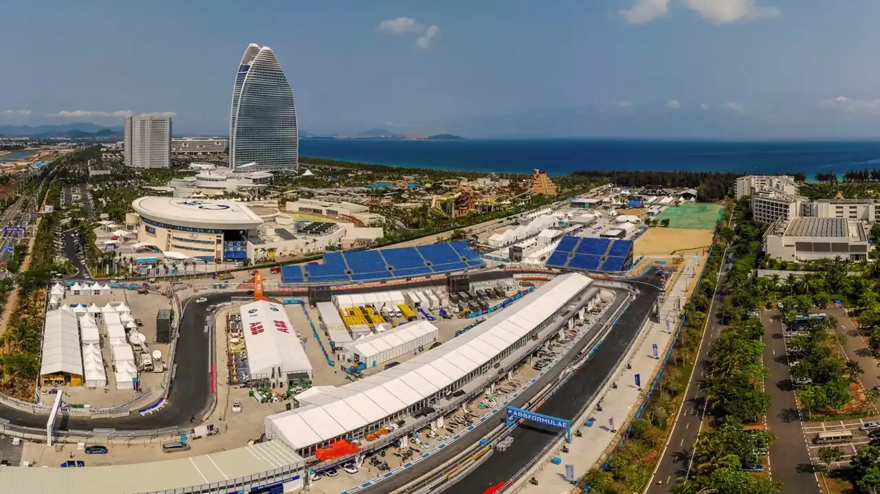 Formula E cars racing on a narrow street circuit with barriers close to the track — Sanya E-Prix 2026
