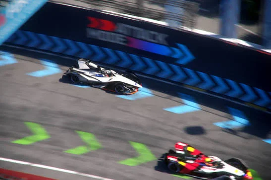 Formula E racing car taking the off-line Attack Mode activation zone on a city street circuit