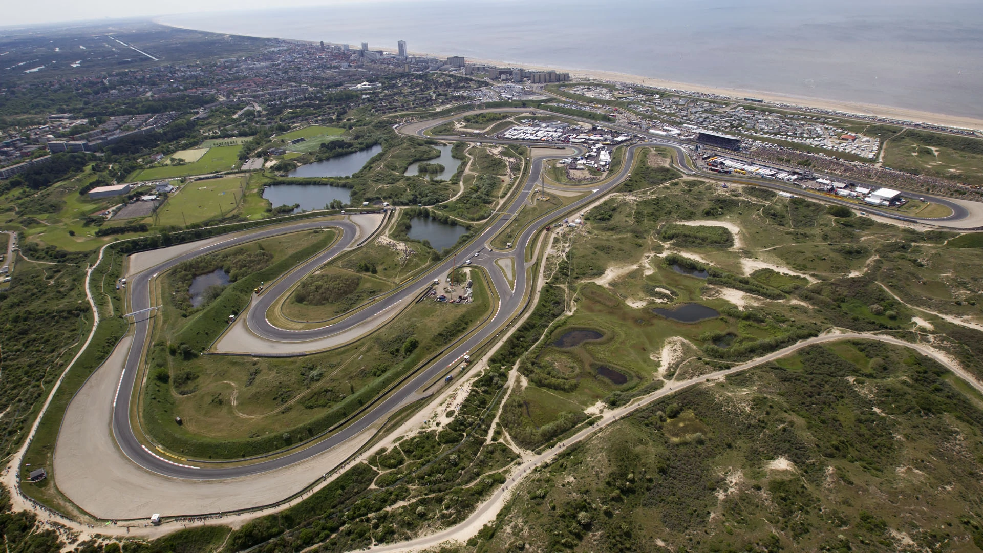 Formula 1 car navigating high-speed banked corner — Circuit Zandvoort Dutch GP atmosphere
