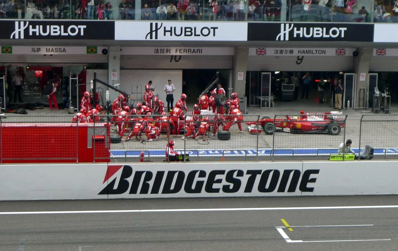 Two Ferrari Formula 1 cars queue during pit stops at the 2010 Chinese Grand Prix