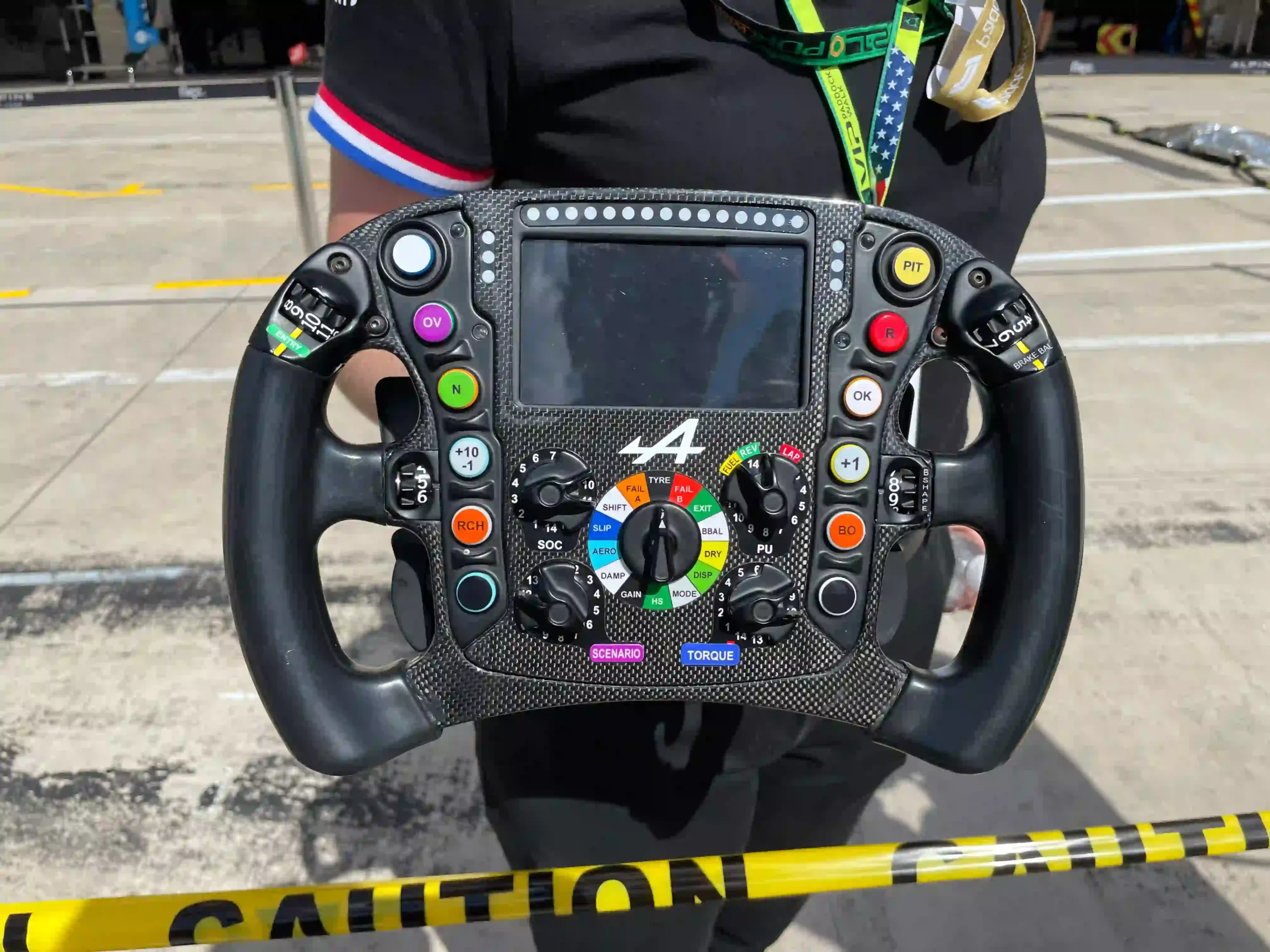 Modern Alpine Formula 1 steering wheel with display, buttons, rotary selectors and hand grips