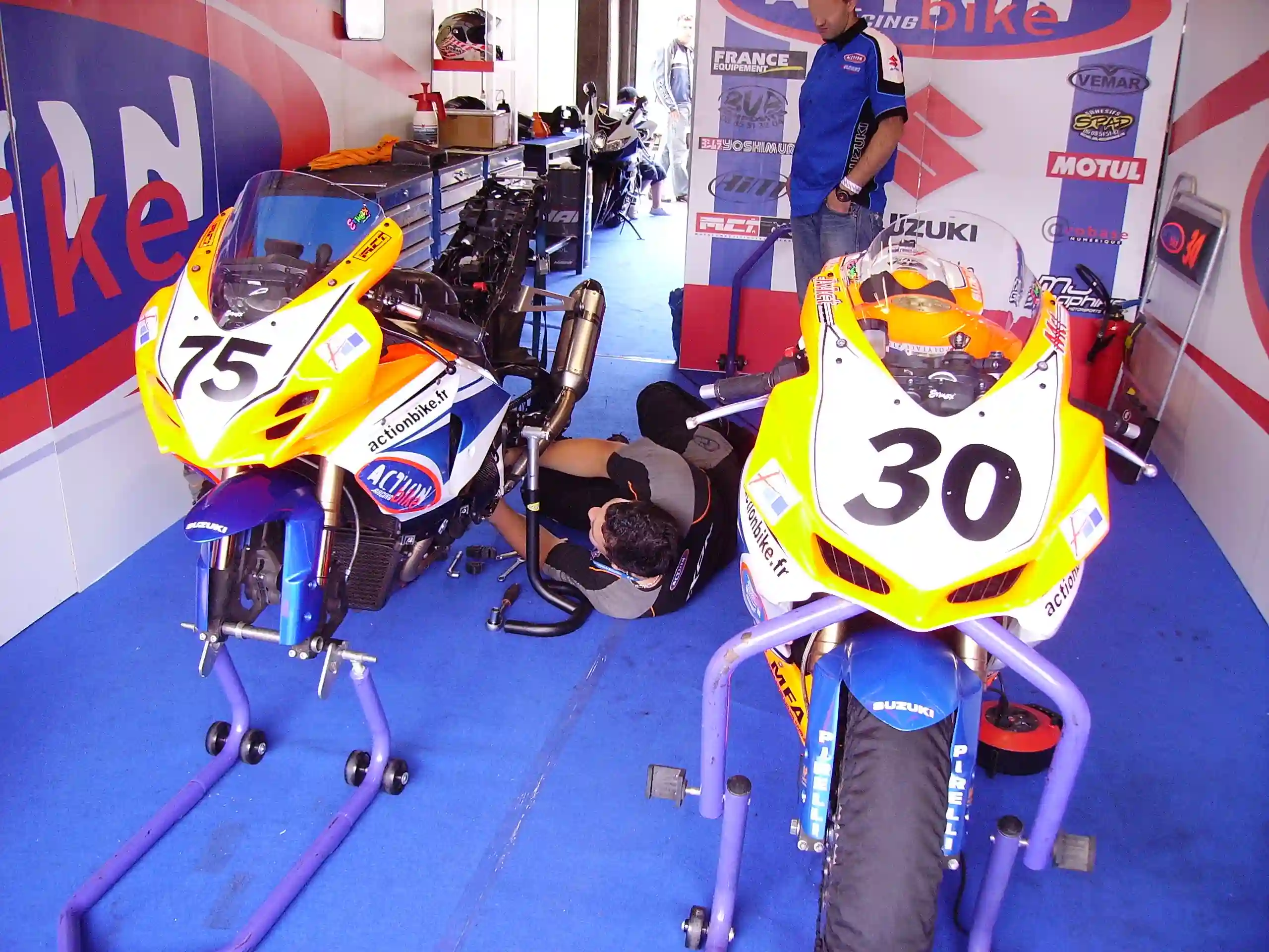 Mechanics repairing a Suzuki GSX-R1000 Superbike in the Magny-Cours paddock
