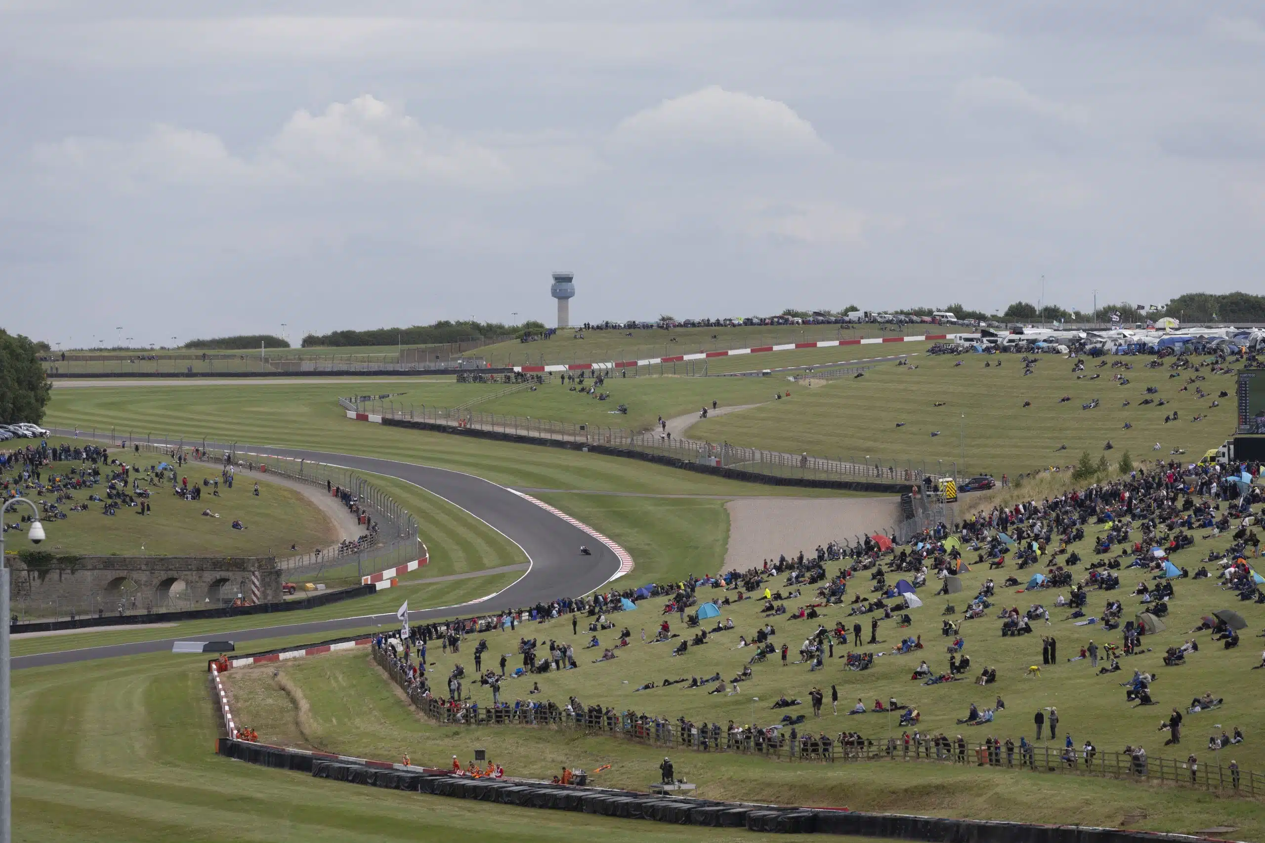 Race motorcycle leaning hard through a banked corner close to the track surface representing WorldSBK superbike racing at Donington Park