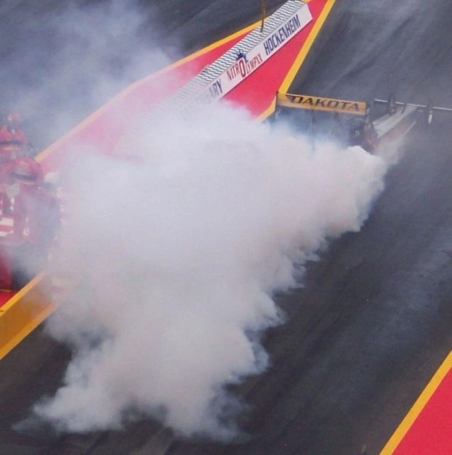 Top Fuel dragster performing a smoky burnout before a nitromethane run