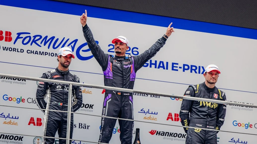 Formula E podium celebration — three drivers on the top step at a street circuit E-Prix