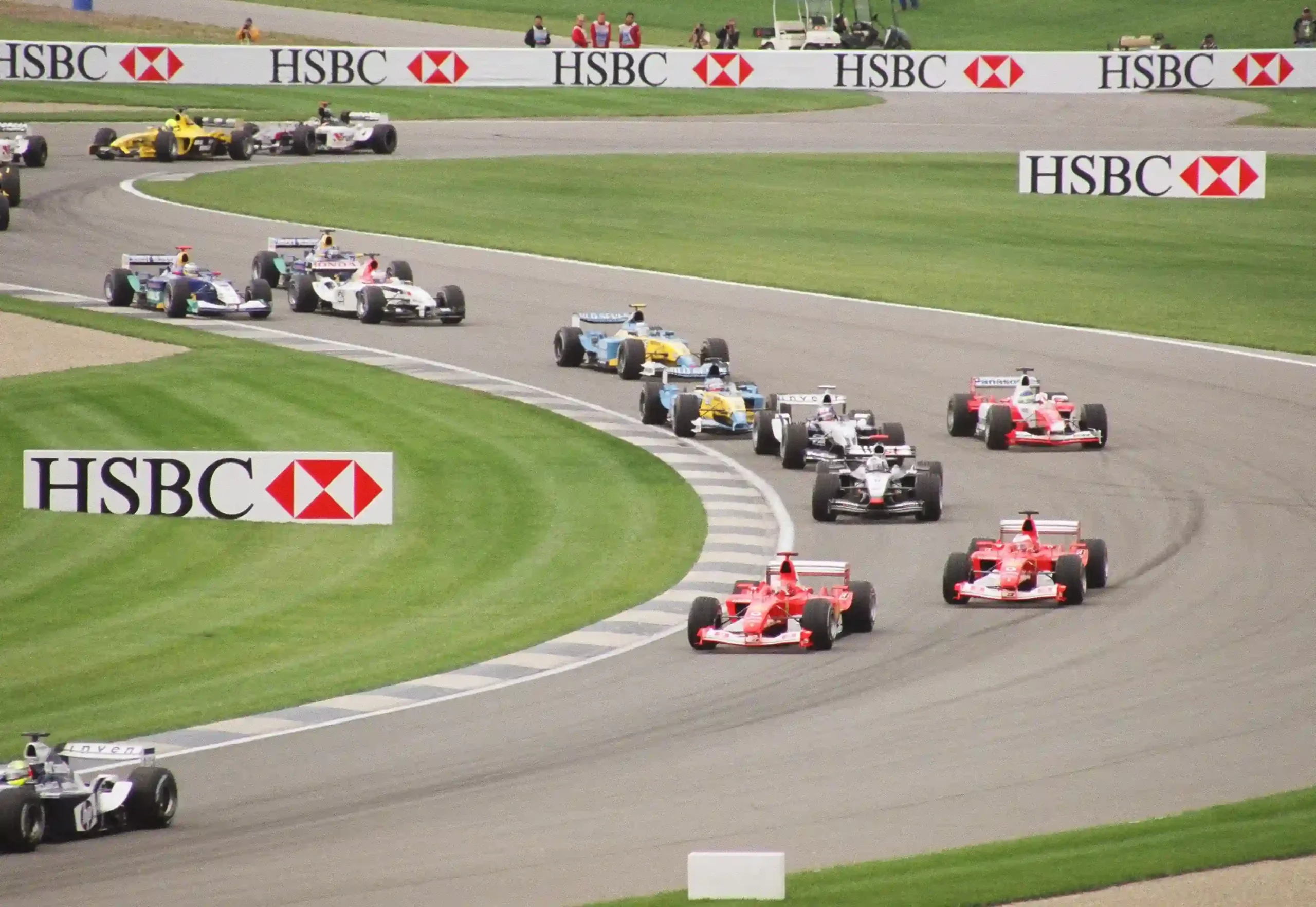 Formula 1 cars racing through the Indianapolis Motor Speedway infield during the 2003 United States Grand Prix