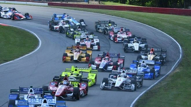 Historic racing car on a natural terrain road course representing the long history of IndyCar at Mid-Ohio Sports Car Course