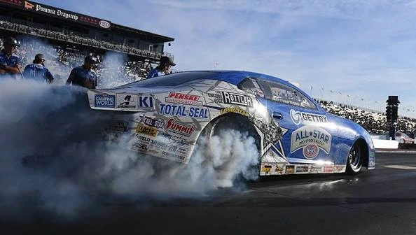 NHRA drag racing pit crew working on a Pro Stock car between rounds at a national event at Summit Motorsports Park