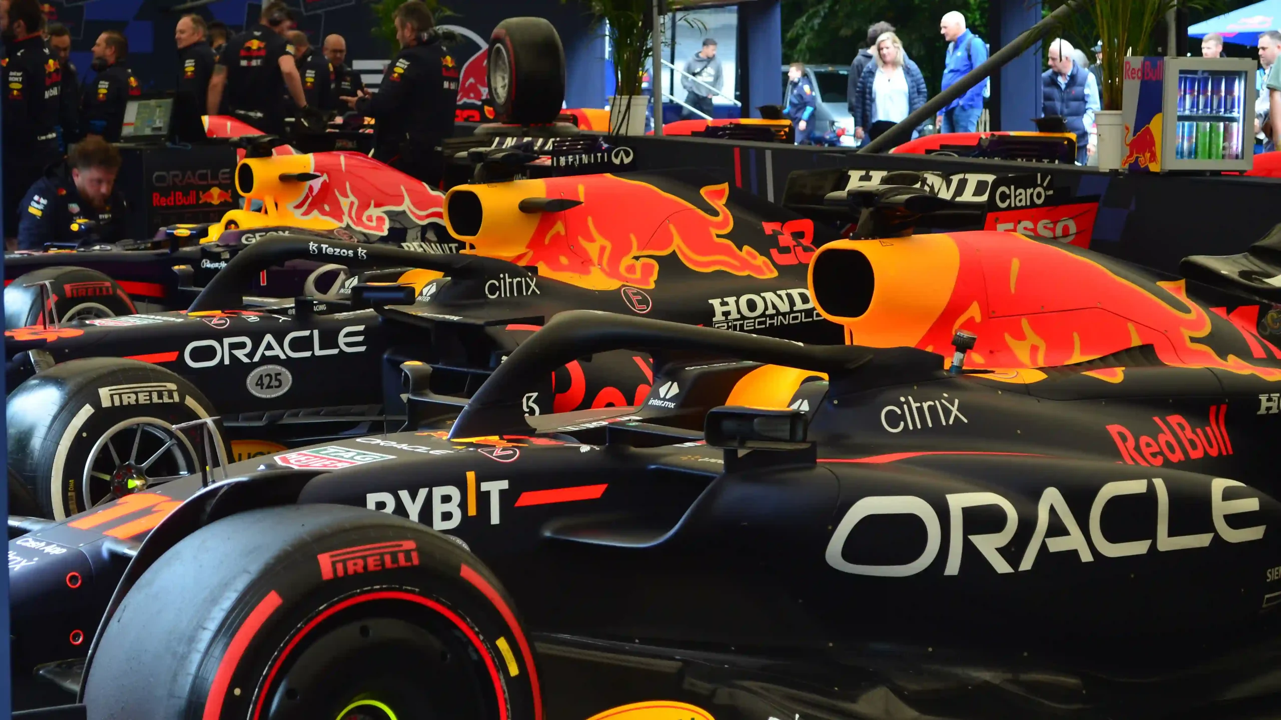 A group of Red Bull Formula 1 cars displayed in a paddock at Goodwood