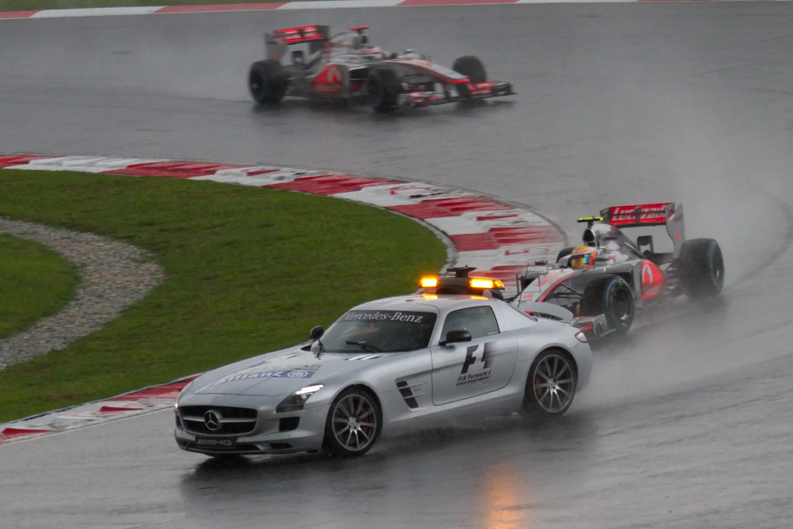 Formula 1 Safety Car leading Lewis Hamilton and Jenson Button at the rain-affected 2012 Malaysian Grand Prix