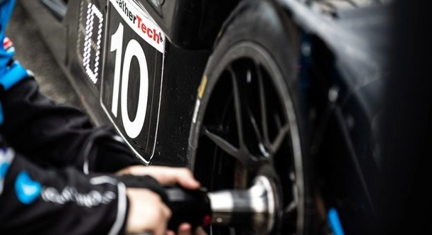 IMSA pit crew member changing a Michelin racing tire