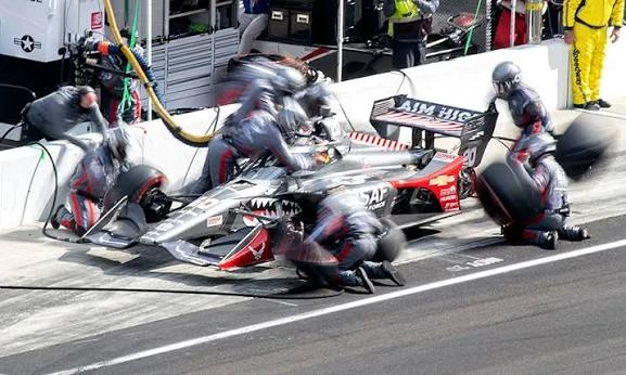 IndyCar pit stop at a natural terrain road course โ pit timing is the decisive strategic variable at Mid-Ohio