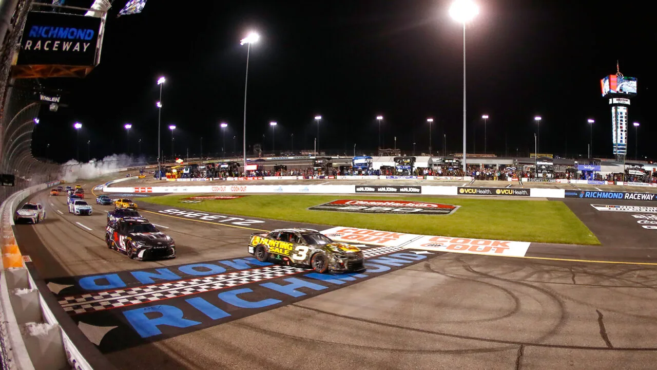 NASCAR Cup Series cars racing to the finish under the lights at Richmond Raceway