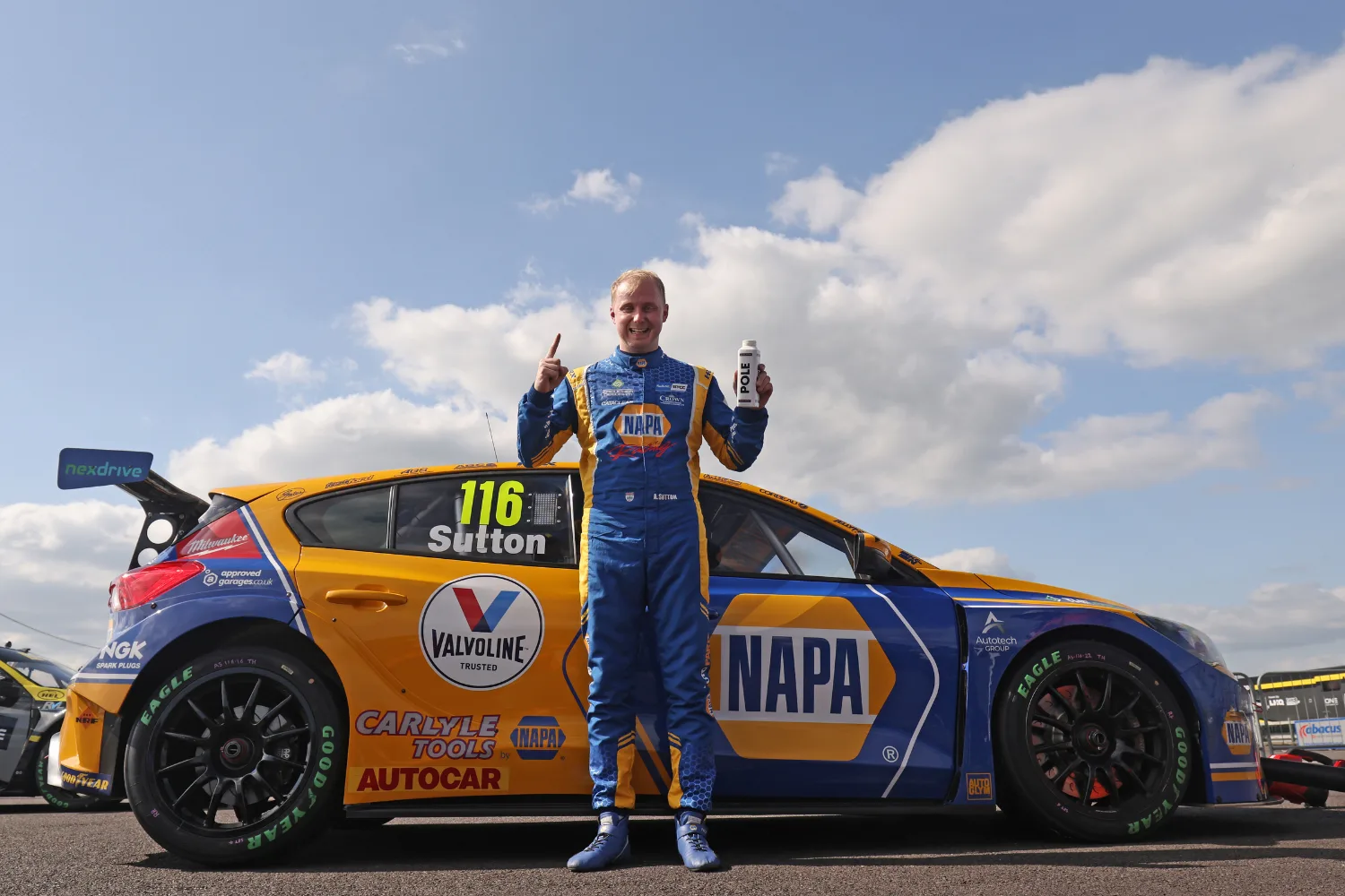 Ashley Sutton standing beside a NAPA Racing UK British Touring Car Championship car