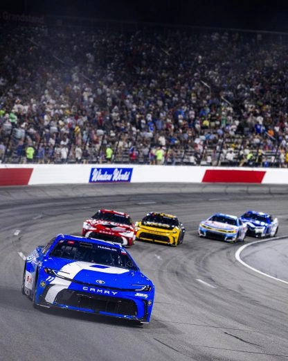 Denny Hamlin leads a pack of NASCAR Cup cars at North Wilkesboro Speedway
