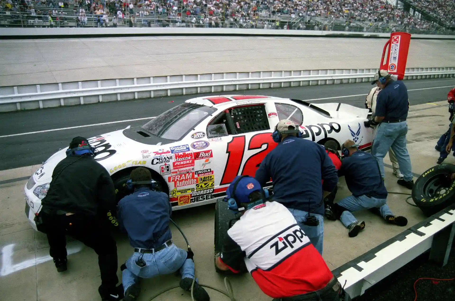 NASCAR pit crew changing tires and refueling during a pit stop