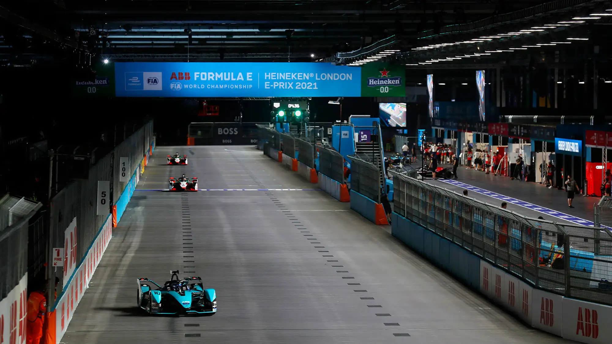 Formula E cars racing through the indoor section of the ExCeL London circuit
